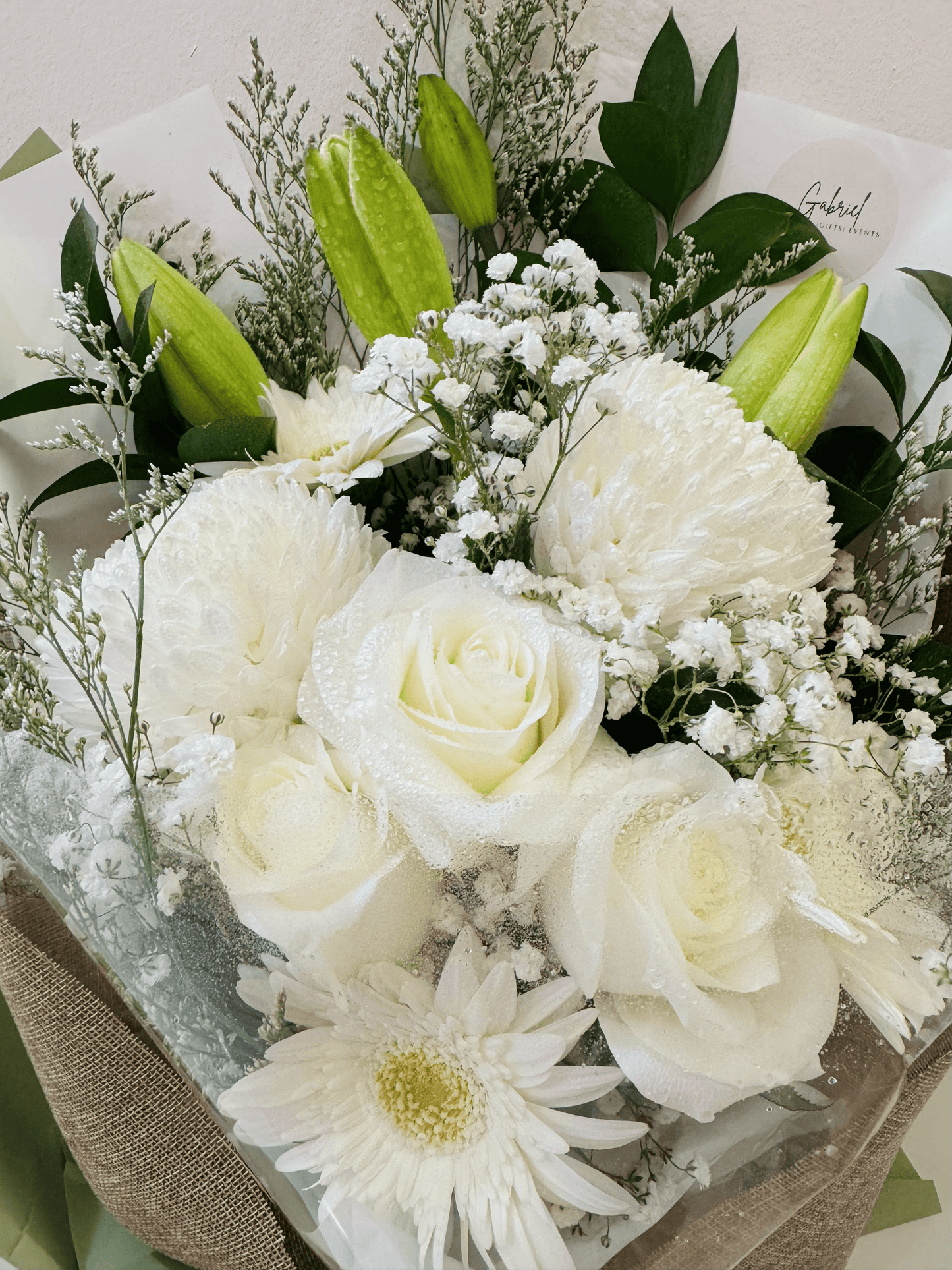 Bouquet of white flowers with greenery on a light background