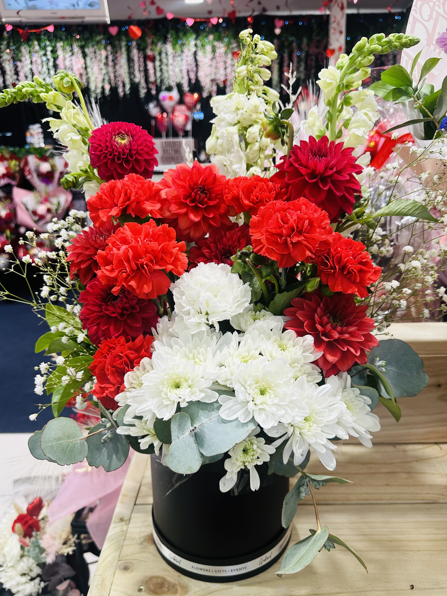 All My Heart Arrangement featuring fresh red dahlias, white chrysanthemums, carnations, and seasonal flowers beautifully arranged in an elegant round box to express love, care, and heartfelt emotions.